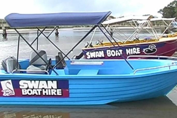 a blue and white boat sitting next to a body of water