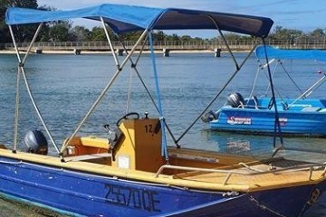 a blue and white boat sitting next to a body of water