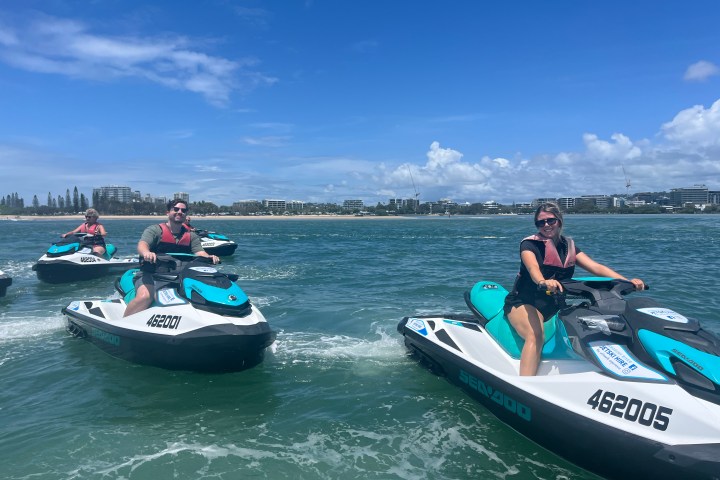a group of people riding on the back of a boat in the water