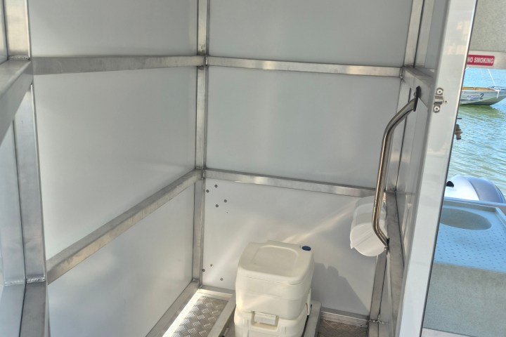 Interior of a small boat bathroom with a portable toilet.